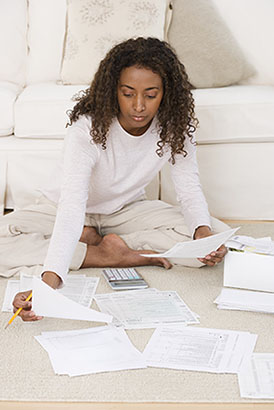 This woman with her taxes spread out on the floor might benefit from a Tax Management Strategy
